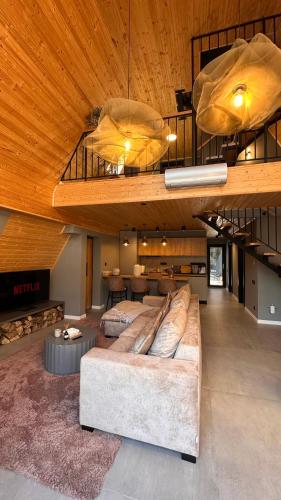 a large couch in a living room with a wooden ceiling at Arboreal Retreat in Văleni
