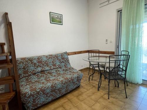 un salon avec un canapé, une table et des chaises dans l'établissement VILLA 6 personnes Heliovillage HV45 -, au Cap d'Agde