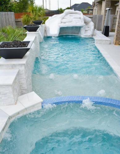 a pool with a water slide in a backyard at Private Houston Oasis Waterfall Pool Jacuzzi in Tomball