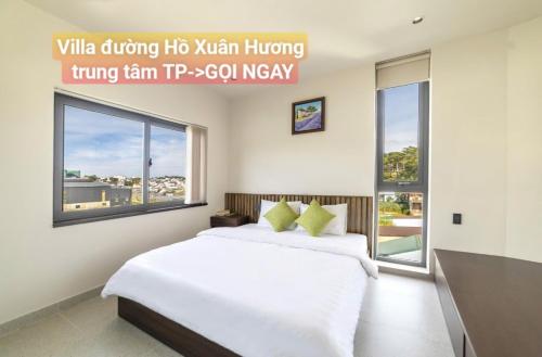 a bedroom with a large white bed and windows at Chillin Villa - Biệt Thự Đà Lạt Khu Nhiều Thông Gần Hồ Tuyền Lâm in Xuan An