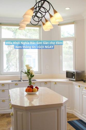 a kitchen with a bowl of fruit on a kitchen island at Chillin Villa - Biệt Thự Đà Lạt Khu Nhiều Thông Gần Hồ Tuyền Lâm in Xuan An