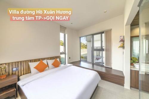 a bedroom with a large white bed and a window at Chillin Villa - Biệt Thự Đà Lạt Khu Nhiều Thông Gần Hồ Tuyền Lâm in Xuan An
