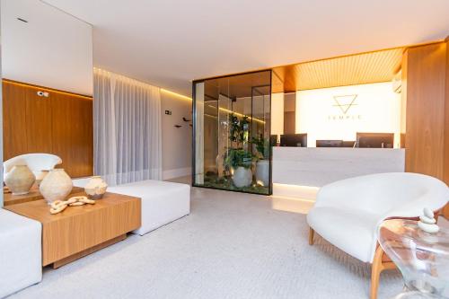 a living room with white furniture and a large mirror at Apartamento Premium c/vaga em Região Nobre-TEM0808 in Curitiba
