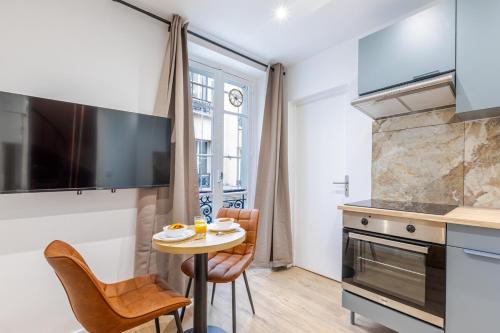 une cuisine avec une petite table et des chaises dans une pièce dans l'établissement Nid douillet pour deux cœur du 19e arrondissement, à Paris