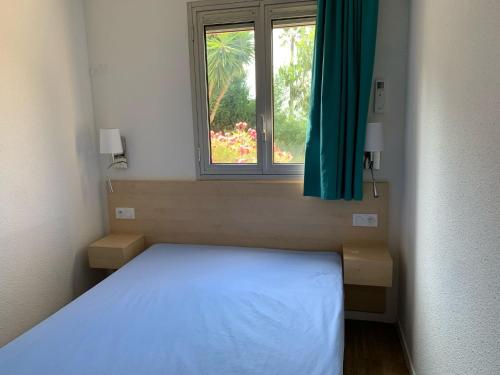 une chambre avec un lit blanc et une fenêtre dans l'établissement Villa Livia, à La Celle-sous-Gouzon