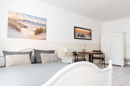 a white bedroom with a bed and a desk at SchaeBu! Appartment 1 Die Ostsee am Altmarkt in Cottbus