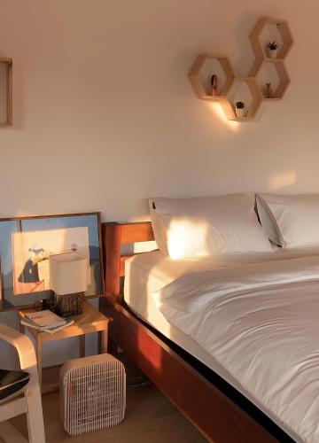 a bedroom with a bed and a table with a lamp at อาเลเล พูลวิลล่า ahlaylay pool villa in Ban Ku Phadu