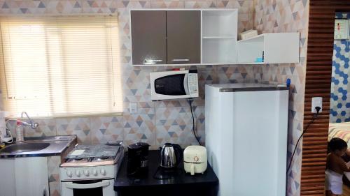 Una cocina con un refrigerador blanco y un microondas. en Casa Completa COP30, en Mosqueiro