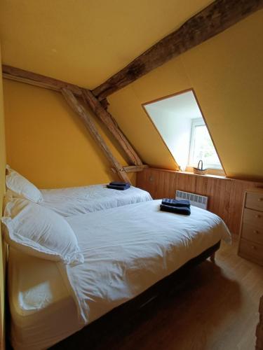 a bedroom with a bed with white sheets and a window at Gîte du Parc Animalier de Boutissaint in Treigny