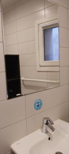 a bathroom with a sink and a mirror and a window at MIJE MARAIS Hostel in Paris