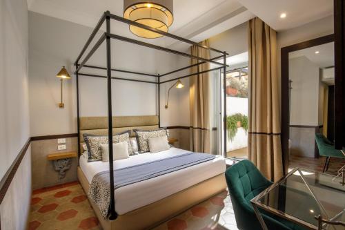 1 dormitorio con cama con dosel y balcón en Flâneur Suites Corso, en Roma