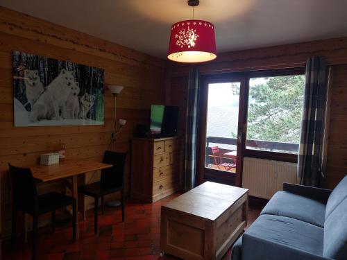 a living room with a couch and a table at studio lumineux La Tournette in Le Grand-Bornand