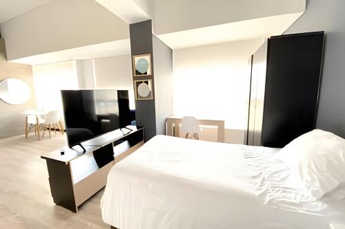 a bedroom with a white bed with a black headboard at Domus Suites Chia in Chía