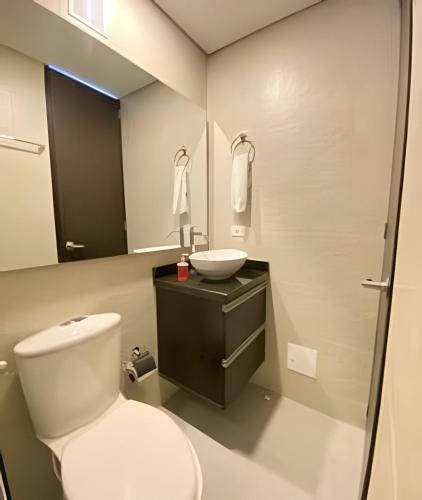 a bathroom with a white toilet and a sink at Domus Suites Chia in Chía