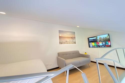 a living room with a couch and chairs at Domus Suites Chia in Chía