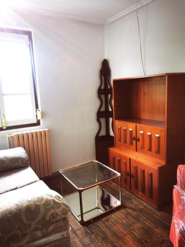 a bedroom with a bed and a dresser and a glass table at Apartamento MIZA in Ponferrada