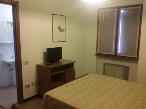 a bedroom with a bed and a tv on a desk at Hotel Fiera in Pesaro