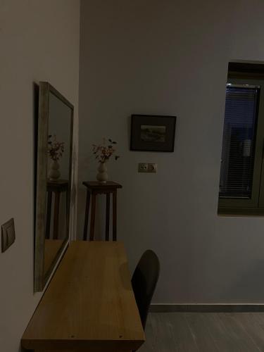a dining room with a wooden table and a mirror at Penelopes Rhapsody Resort in Mesolongion