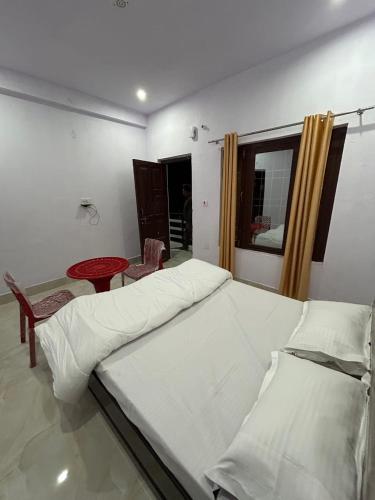 a bedroom with a bed and a table and a window at Hotel new yamuna Putra in Kharsālī