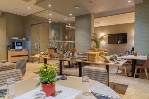 Un restaurante con mesas y sillas y una cocina. en Pestana Tanger - City Center Hotel Suites & Apartments, en Tánger