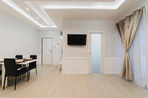 d'une salle à manger avec une table et une télévision murale. dans l'établissement Cuore D'aMare B&B, à Bari