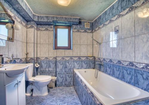 a bathroom with a tub and a toilet and a sink at Domki i pokoje przy ujściu in Solina