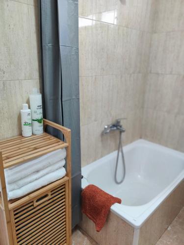 a bathroom with a tub and a shower with towels at Alojamiento céntrico Ribeira con parking sin ascensor in Ribeira
