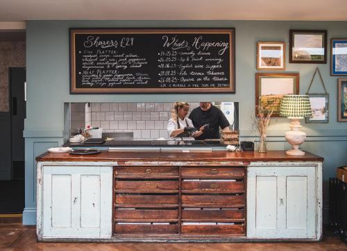 a man and woman standing behind a counter in a restaurant at Bel and The Dragon-Odiham in Odiham