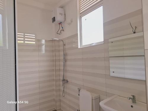ein Badezimmer mit Dusche, Toilette und Waschbecken in der Unterkunft Vimara in Hikkaduwa