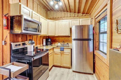 a kitchen with a stainless steel refrigerator and wooden cabinets at River Views, Deck and Boat Slip Heber Springs Home! in Heber Springs