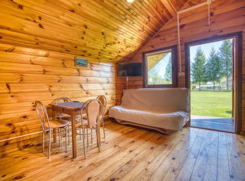a room with a bed and a table and chairs at Domki i pokoje przy ujściu in Solina