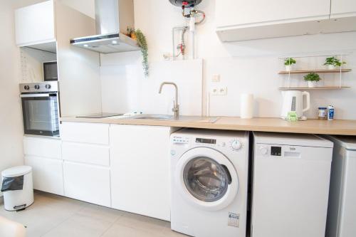 - une cuisine blanche avec lave-linge et sèche-linge dans l'établissement Le Petit Clos'y - Appart hypercentre avec parking + terrasse, à Amboise