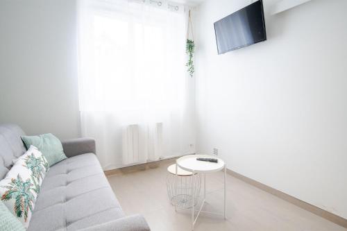 un salon avec un canapé et une table dans l'établissement Le Petit Clos'y - Appart hypercentre avec parking + terrasse, à Amboise