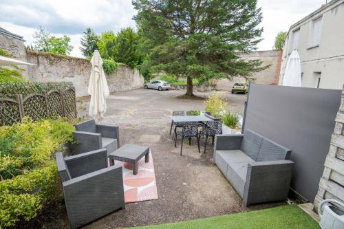 une terrasse avec des chaises, une table, une table et un parasol dans l'établissement Le Petit Clos'y - Appart hypercentre avec parking + terrasse, à Amboise