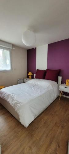 - une chambre avec un grand lit et un mur pourpre dans l'établissement Appartement l'Étoile pour 1 à 4 personnes, à Sallanches
