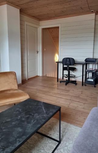 a living room with a couch and a table at Hus med fin uteplass - nær E39, natur og shopping in Sandnes