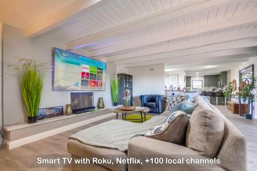 Una sala de estar con un sofá y un televisor. en Entire Private 3-Bedroom Home w Gated Yard, 100 inch TV, 1 Gbps WiFi, Available Now, en San Diego