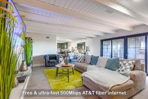 una sala de estar con un sofá y una mesa en Entire Private 3-Bedroom Home w Gated Yard, 100 inch TV, 1 Gbps WiFi, Available Now, en San Diego