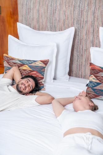 two women laying on a bed next to each other at Rose Aqua Park Hotel in Marrakesh