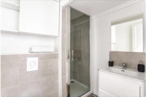 une salle de bain avec une douche, un lavabo et un miroir dans l'établissement Jolie appartement proche de la joliette 14LAN, à Marseille