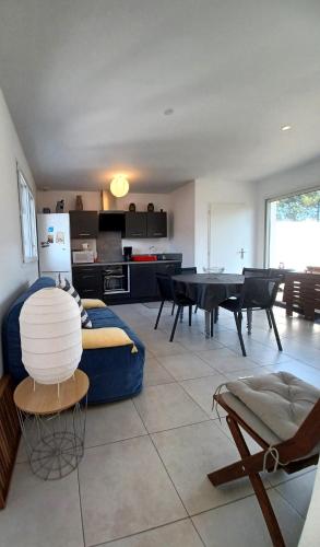 un salon avec un canapé bleu et une table dans l'établissement Patio de Flore, à Mimizan