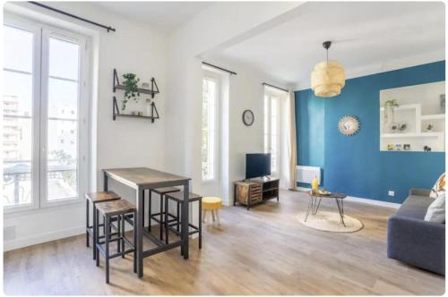 un salon avec une table et un mur bleu dans l'établissement Jolie appartement proche de la joliette 14LAN, à Marseille