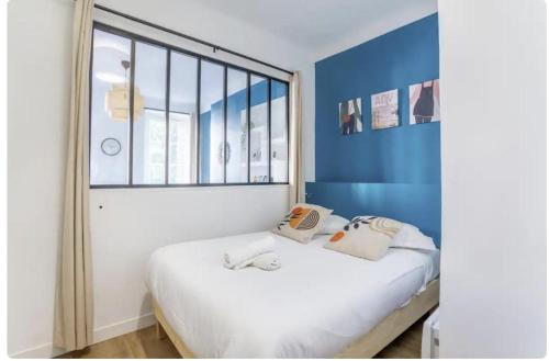 une chambre avec un lit avec une grande fenêtre dans l'établissement Jolie appartement proche de la joliette 14LAN, à Marseille