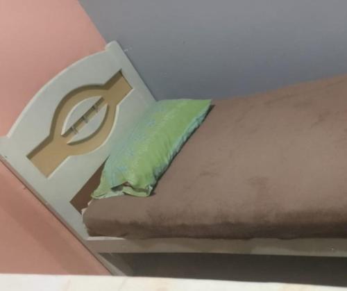 a green pillow sitting on top of a bed at Hostel vila nova in Niterói