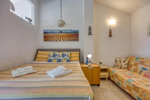 a bedroom with a bed and a couch at Mikelic Stara Barbariga in Barbariga