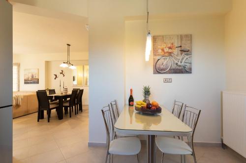 a kitchen and dining room with a table with a bowl of fruit at Villa Callisti in Pylos