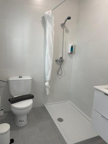 a white bathroom with a toilet and a shower at CH II Apartments ZONA DE OCIO NOCTURNO in Conil de la Frontera