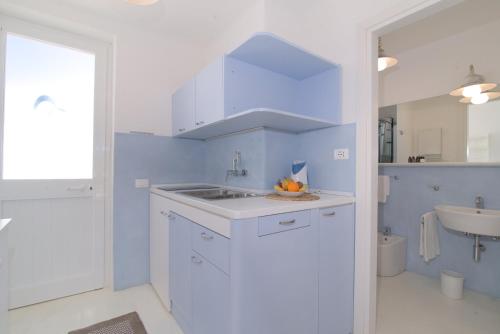 a blue and white bathroom with a sink and a mirror at Villa Ravino Secret Retreat in Ischia