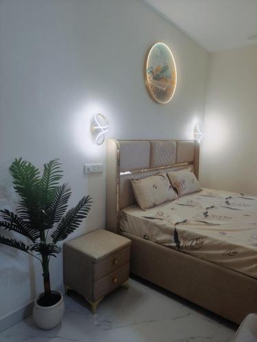 a bedroom with a bed and a potted plant at Iconic Royal Studio Apartment Near Expo Mart in CHI 5 in Greater Noida