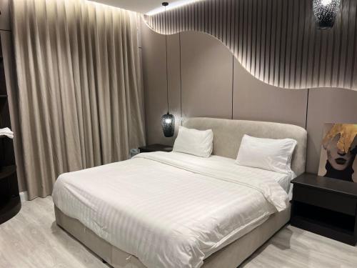 a bedroom with a large bed with white sheets at شقق راحتي جازان للشقق المخدومة in Jazan